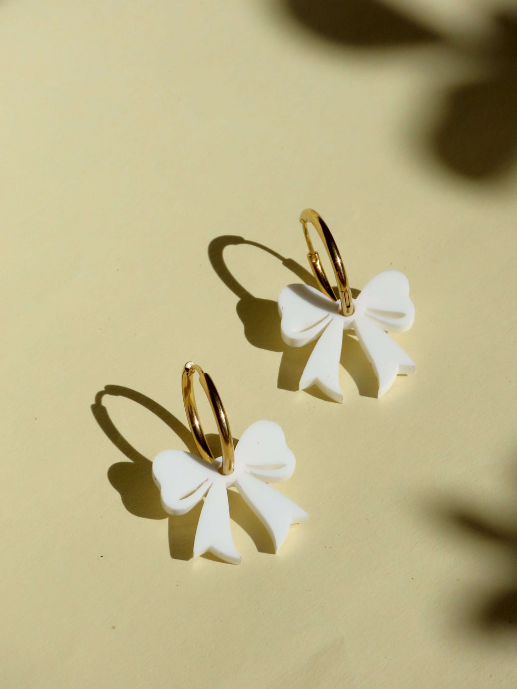 Goldene Creolen mit weißen Schleifen – verspielte Ohrringe mit 3D-Effekt